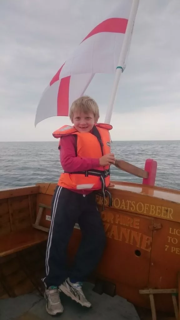 kids mackeral fishing of the beach in beer devon on a boat